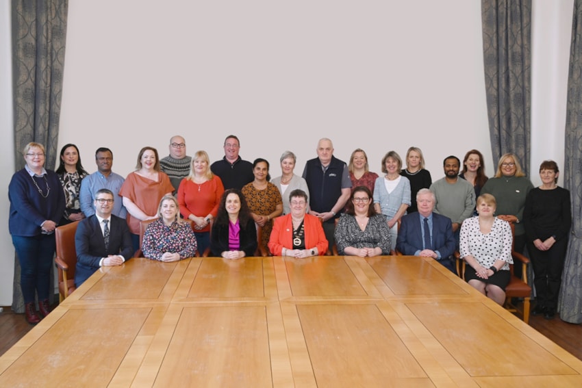 INMO Executive Council group photo sitting at a boardroom table smiling at the camera